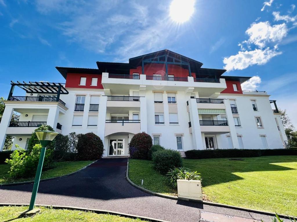 een groot wit gebouw met een rood dak bij Appartement Cambo-les-Bains, 3 pièces, 4 personnes - FR-1-495-18 in Cambo-les-Bains