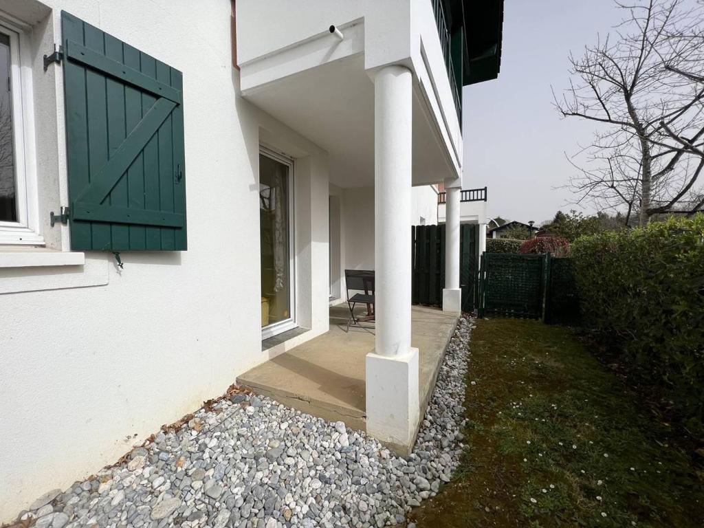 een huis met een groene deur en een stoel op een veranda bij Appartement Cambo-les-Bains, 2 pièces, 4 personnes - FR-1-495-33 in Cambo-les-Bains