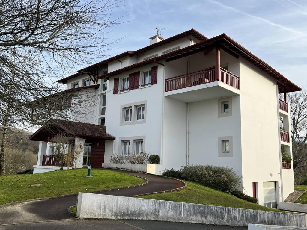 a white building with a balcony on a road at Appartement Cambo-les-Bains, 2 pièces, 3 personnes - FR-1-495-76 in Cambo-les-Bains