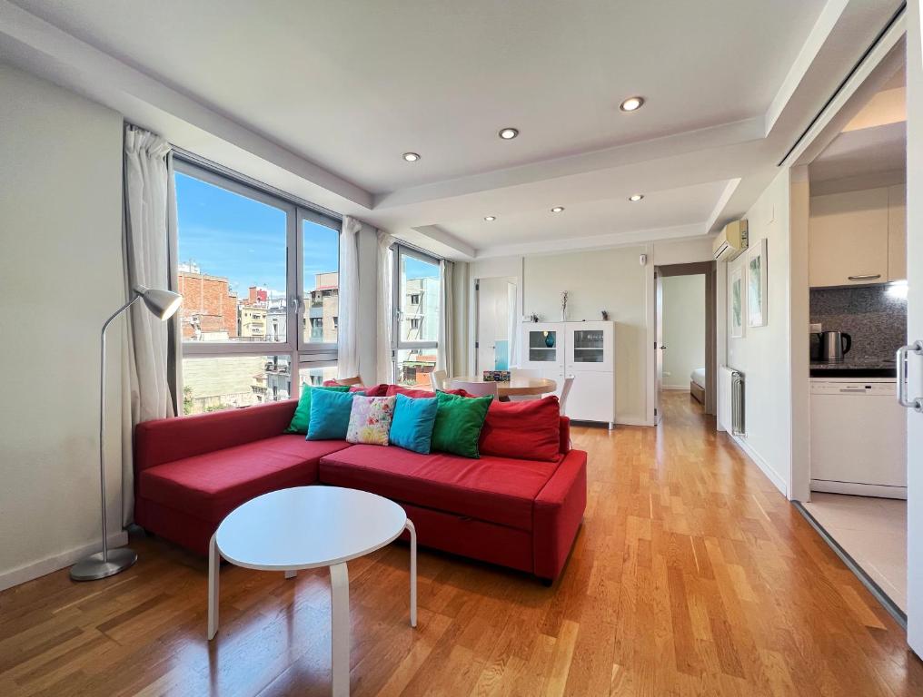sala de estar con sofá rojo y mesa en Stay U-nique Apartments Degà Bahí en Barcelona