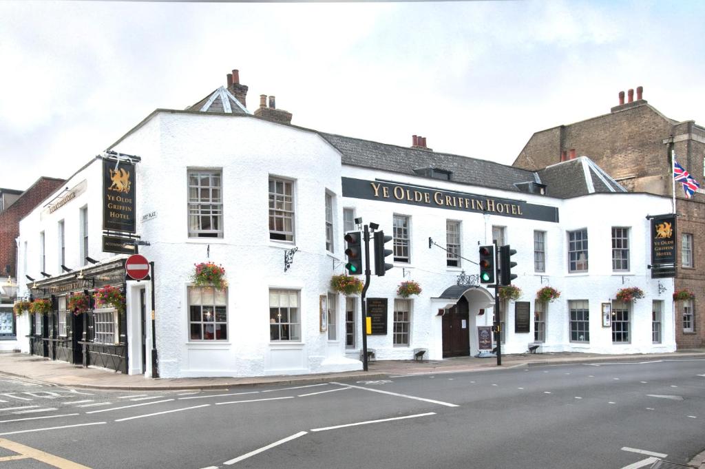 un bâtiment blanc au coin d'une rue dans l'établissement Ye Olde Griffin, à March