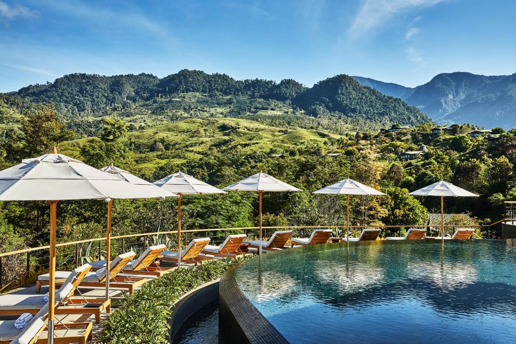 una piscina con tumbonas y sombrillas en Hacienda AltaGracia, Auberge Resorts Collection, en Santa Elena