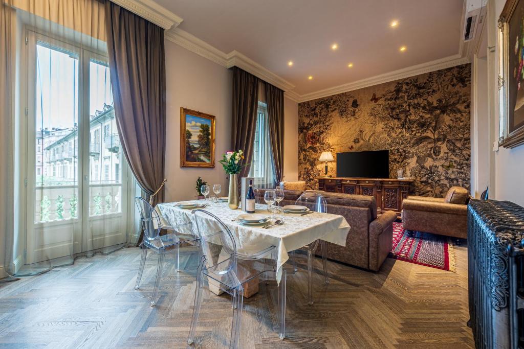 uma sala de jantar com uma mesa e uma sala de estar em Plaza View Luxury Apartment, Alba em Alba