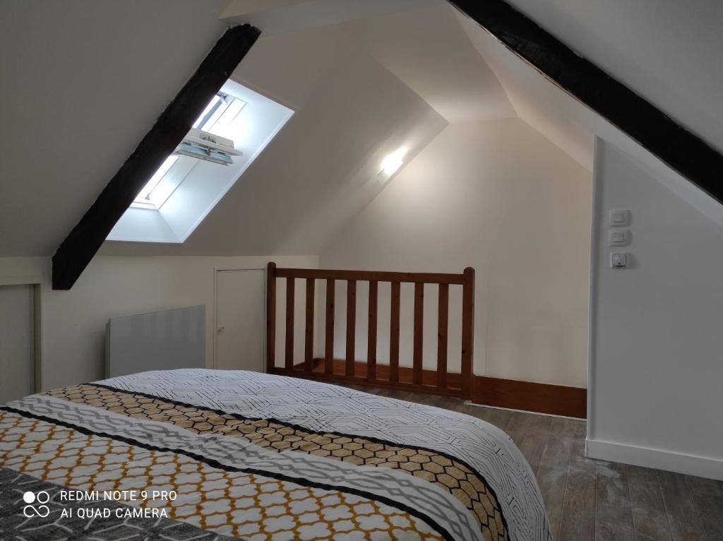 a bedroom with a bed and a skylight at Le gîte de ty stumo1 in Neulliac