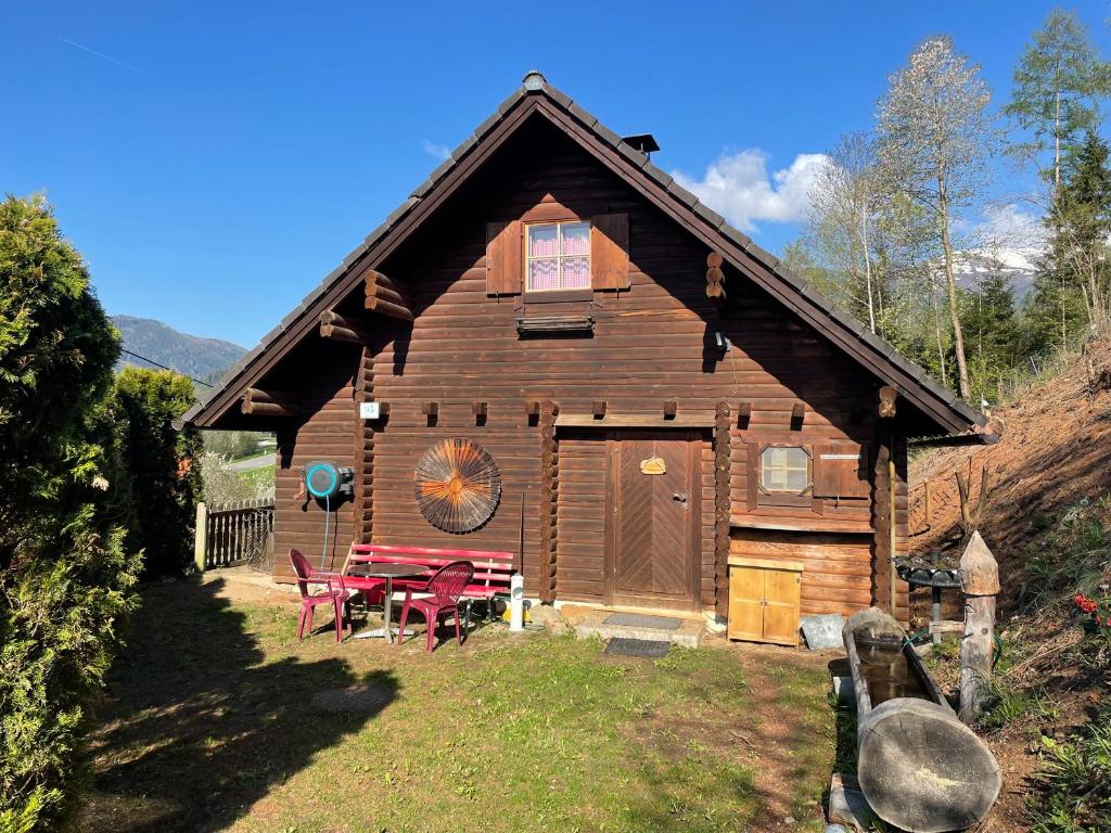 una cabaña de madera con una mesa de picnic delante de ella en Ferienhütte Bosic, en Baierdorf