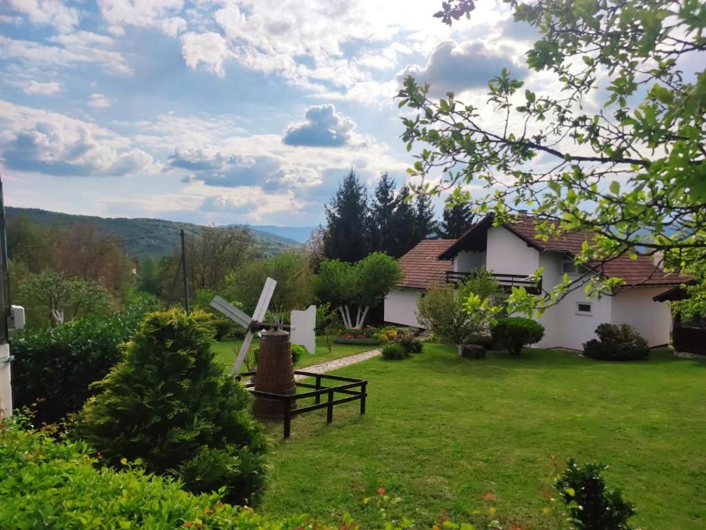 a house with a windmill in a yard at Guest house Jandric in Drežnik Grad