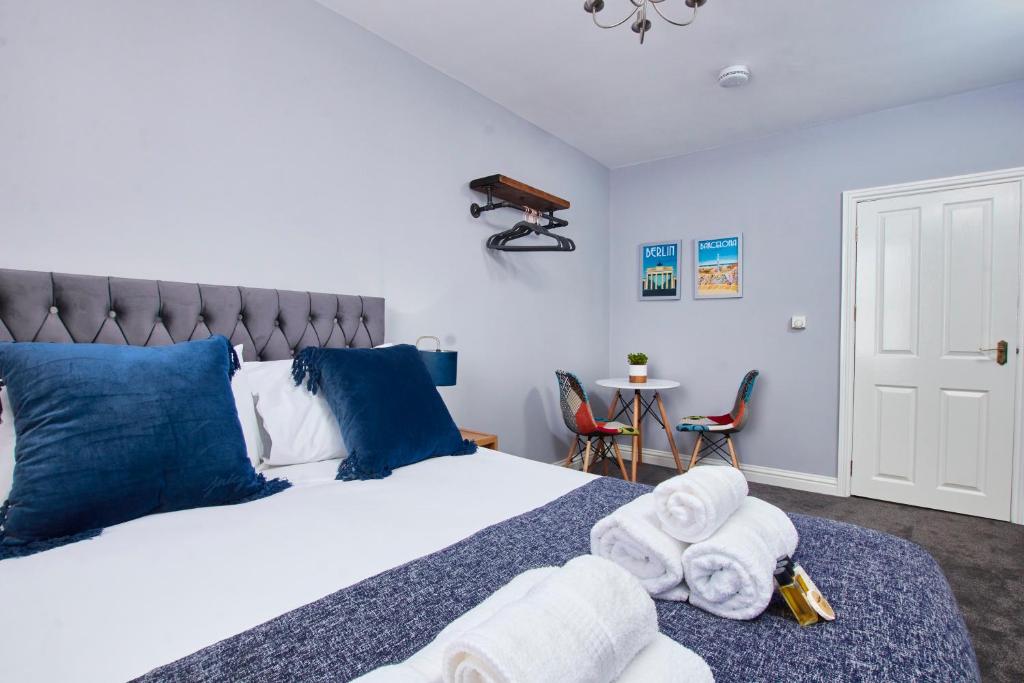 um quarto com uma cama grande e toalhas em Delven House, Apartment 5 em Castle Donington