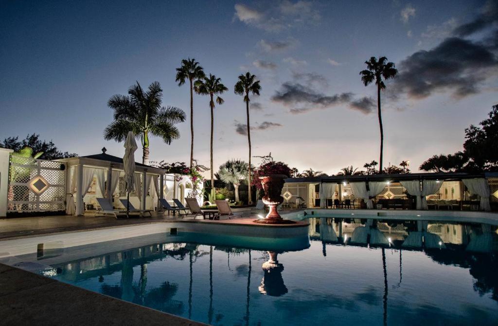 a swimming pool with palm trees in the background at Villa Piera Maspalomas in Maspalomas