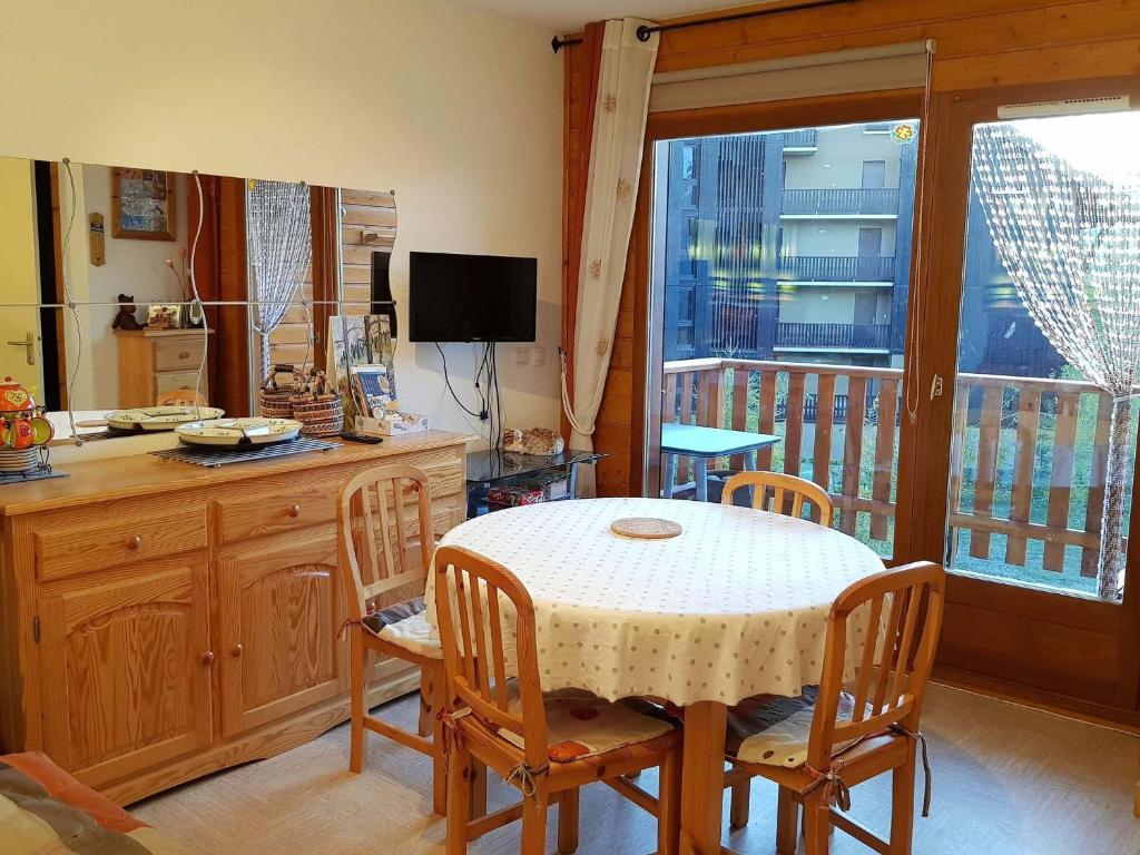a kitchen with a table and chairs and a balcony at Appartement La Joue du Loup, 3 pièces, 6 personnes - FR-1-504-158 in Le Dévoluy