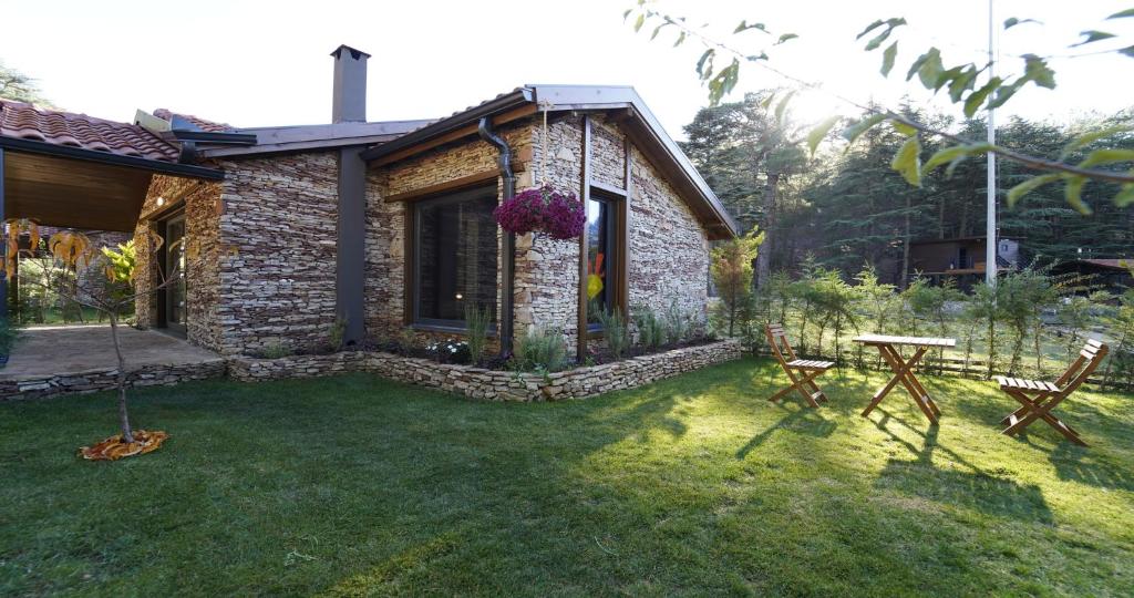 a yard with a stone house with a table and chairs at Cragus Inn Fethiye in Karaagac