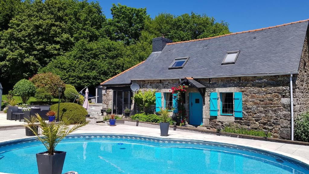 a house with a swimming pool in front of a house at Maroux Vian Country Cottage in Callac