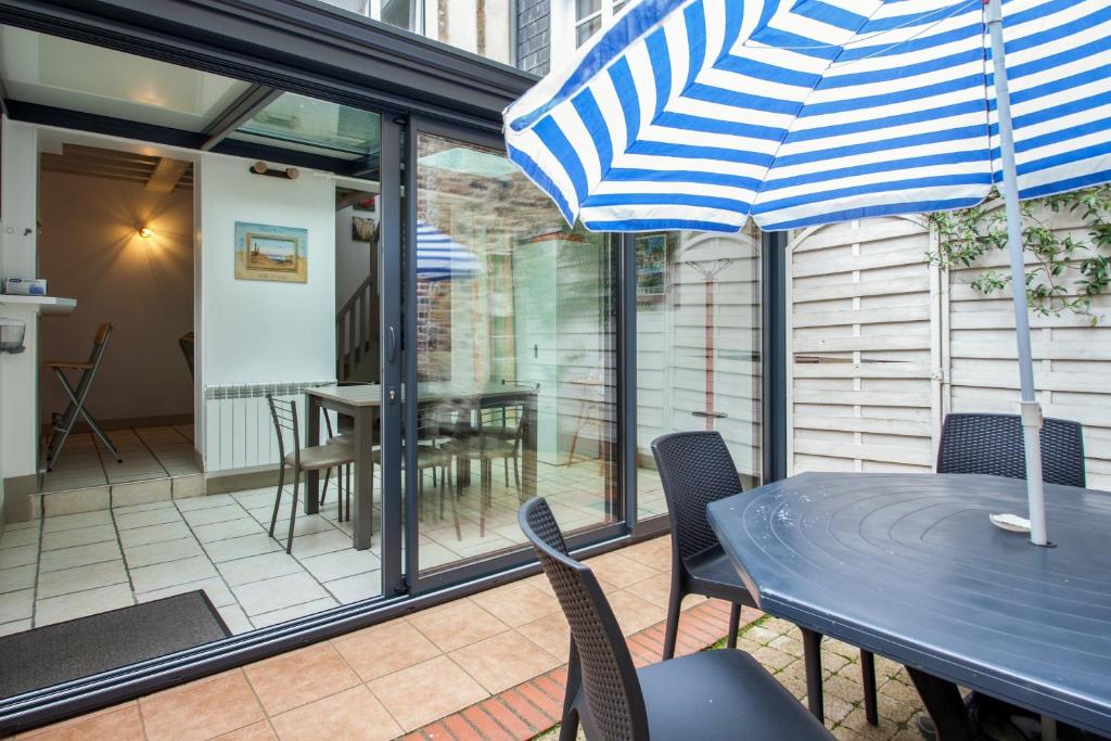 a patio with a table and chairs and an umbrella at Maison de 2 chambres avec wifi a Honfleur in Honfleur