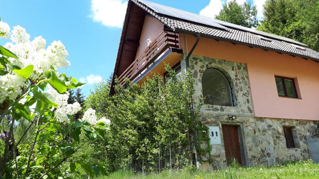 an old house in a garden with flowers at Country House & Spa in Mislinja