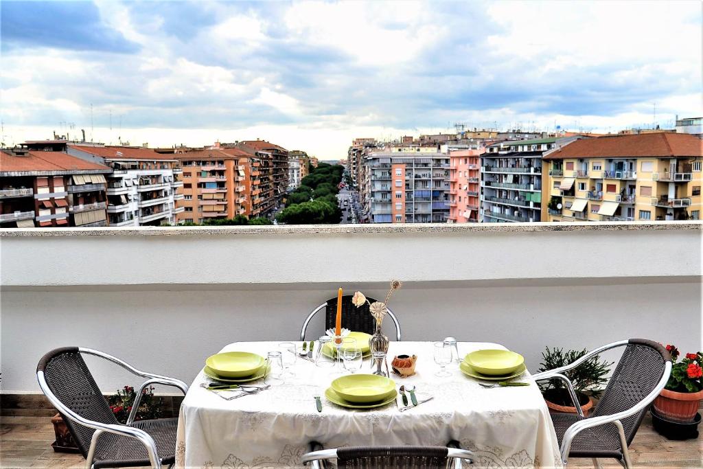 una mesa en un balcón con vistas a los edificios en Attico luminoso terrazza Metro A Aria Cond WiFi en Roma