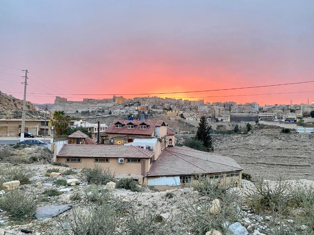 un groupe de maisons dans une ville au coucher du soleil dans l'établissement Cairwan Hotel, à Al-Karak