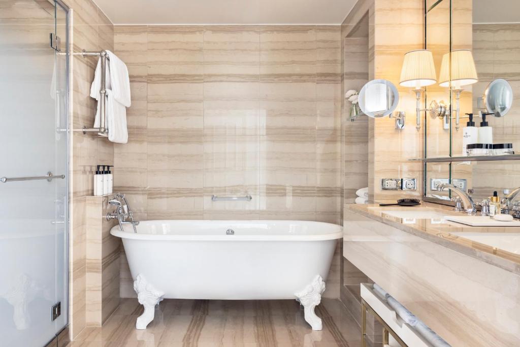 a bathroom with a white tub and two sinks at InterContinental Paris Le Grand by IHG in Paris
