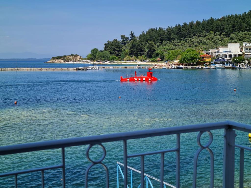 a red boat in a large body of water at Kikis house in Limenas