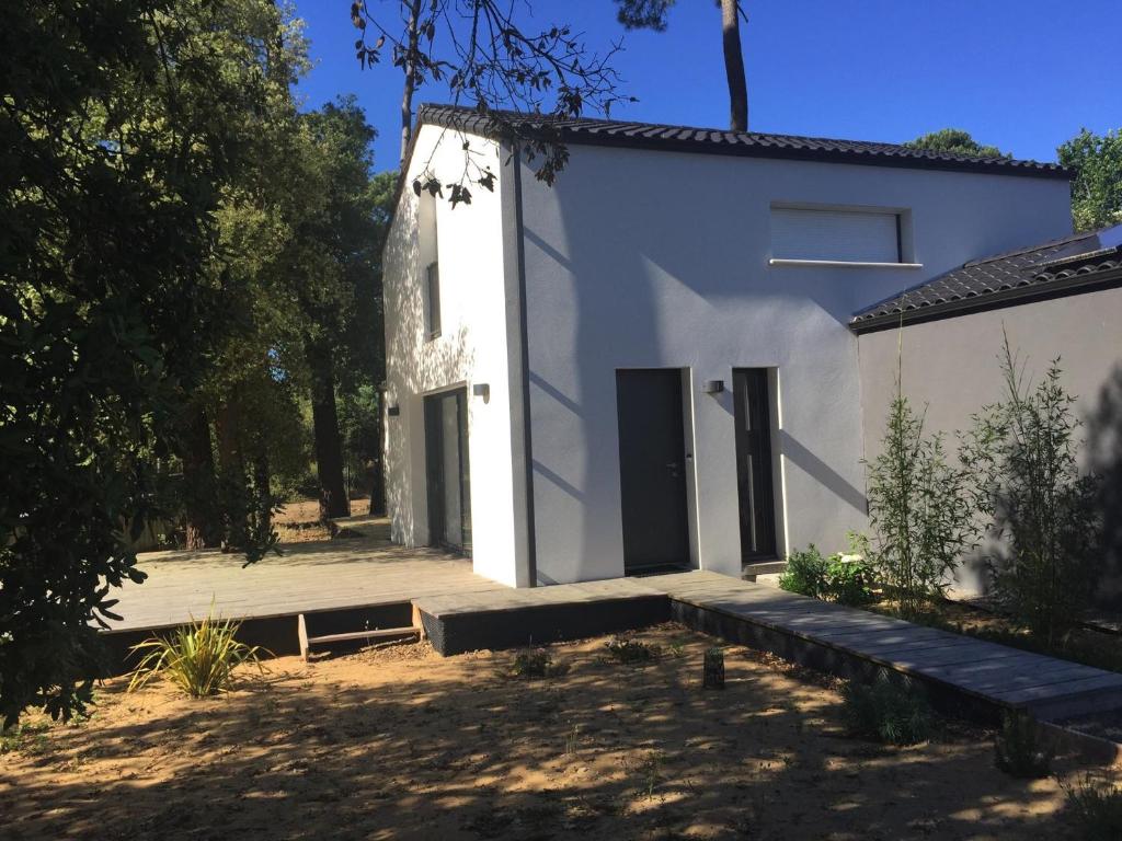 une maison blanche avec une cour et des arbres dans l'établissement Maison Jard-sur-Mer, 4 pièces, 8 personnes - FR-1-336-104, à Jard-sur-Mer