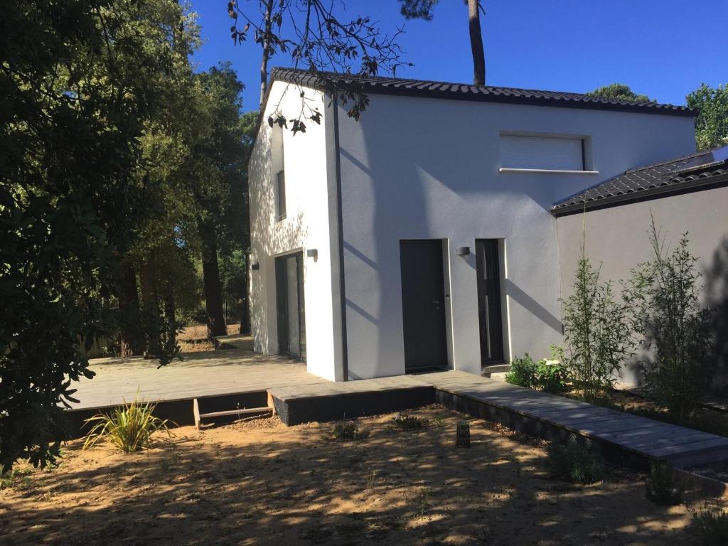 a white house with a courtyard and trees at Maison Famille 8 pers, Jardin et Terrasse à Jard-sur-Mer - FR-1-336-104 in Jard-sur-Mer