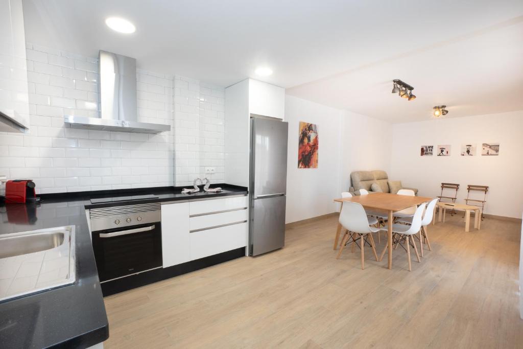 a kitchen with a table and a stainless steel refrigerator at A&F Apartments in Nerja