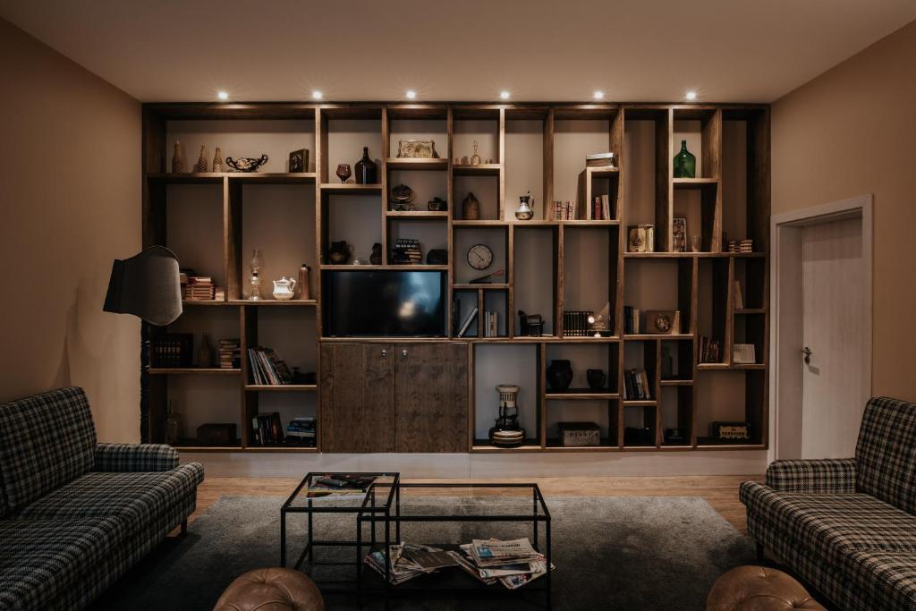 uma sala de estar com dois sofs e uma TV em Casa das Muralhas na Covilh