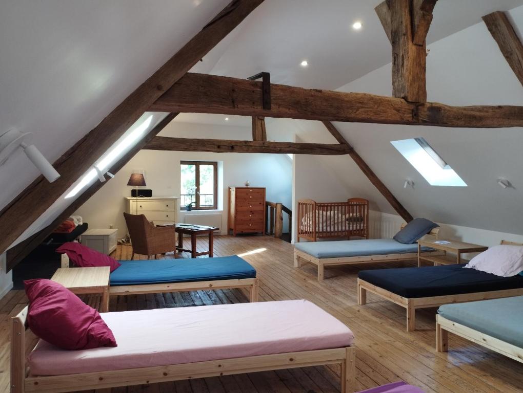 a living room with wooden floors and wooden beams at Le refuge d'Athéna in Chaussy