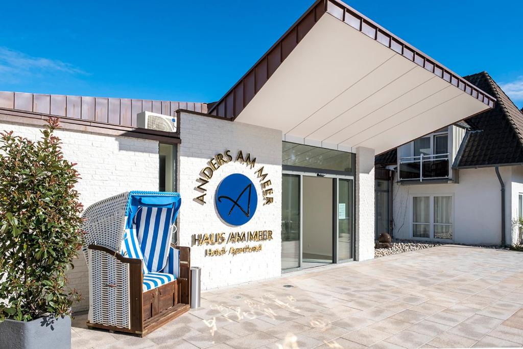 a wicker chair sitting in front of a building at Hotel Haus am Meer in Hohwacht