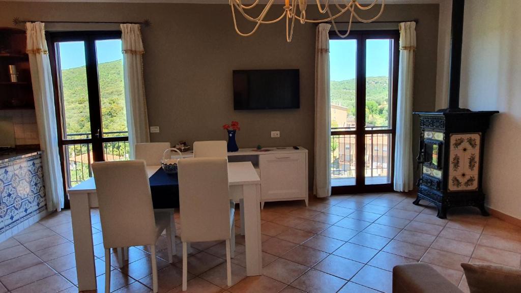 a dining room with a table and chairs and a television at Delizioso appartamento a Capalbio con vista in Capalbio