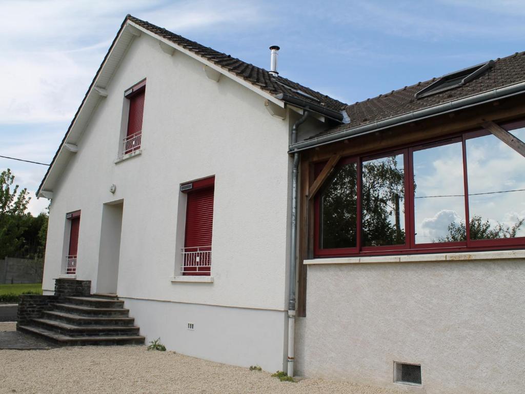 a white house with red windows and stairs at Maison La Roche-Posay, 5 pièces, 7 personnes - FR-1-541-17 in La Roche-Posay