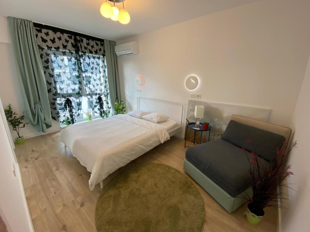 une chambre avec un lit, une chaise et une fenêtre dans l'établissement Green apartments 109-7 with roof top view, à Bucarest