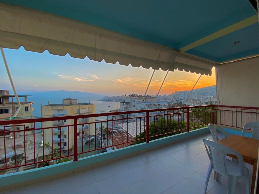 einen Balkon mit Blick auf das Meer bei Sonnenuntergang in der Unterkunft Panoramic Apartment Amelia in Sarandë