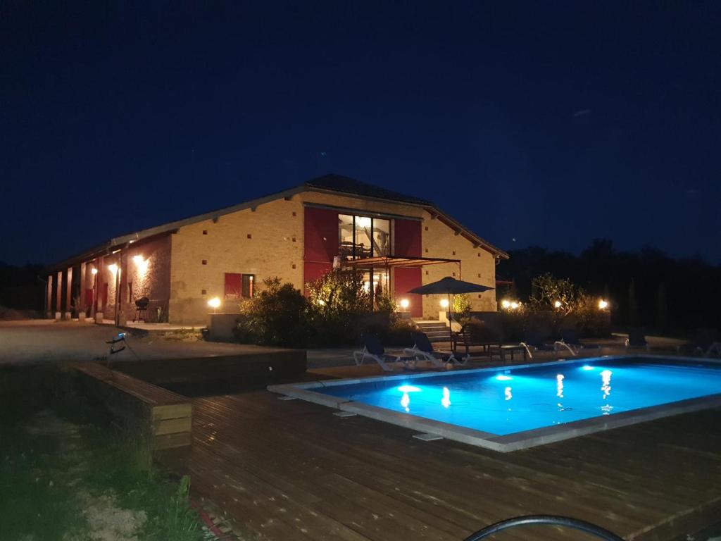 a swimming pool in front of a building at night at exceptionnel loft style industriel tout équipé 15 personnes avec jacuzzi in Villebramar