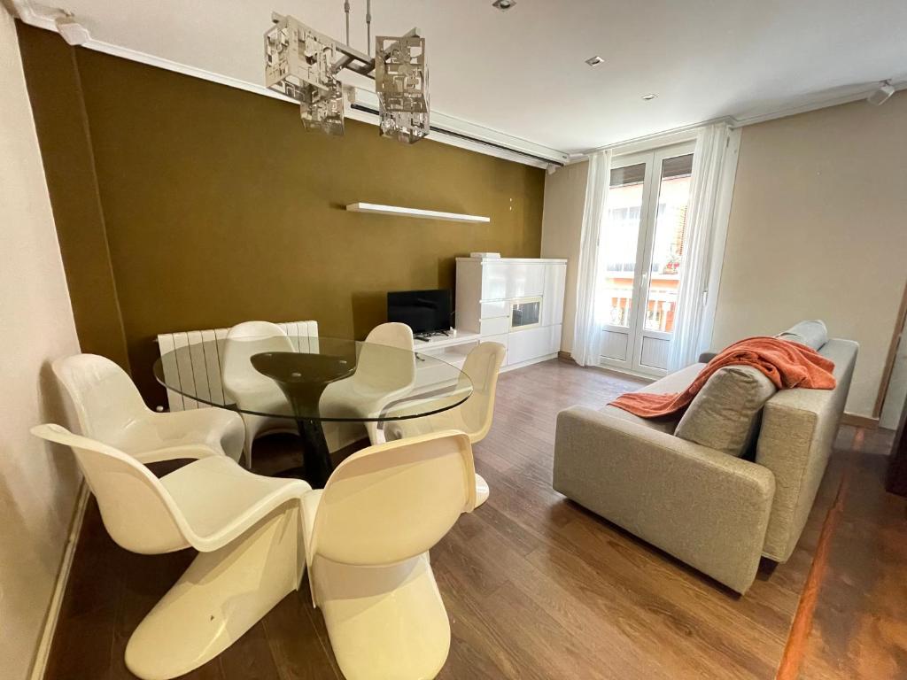 a dining room with a table and chairs and a couch at Uribarri Home Bilbao in Bilbao