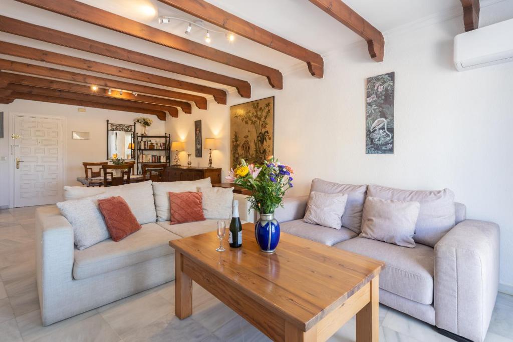 - un salon avec deux canapés et une table en bois dans l'établissement Comfortable Yacht Club Apartment, à Marbella