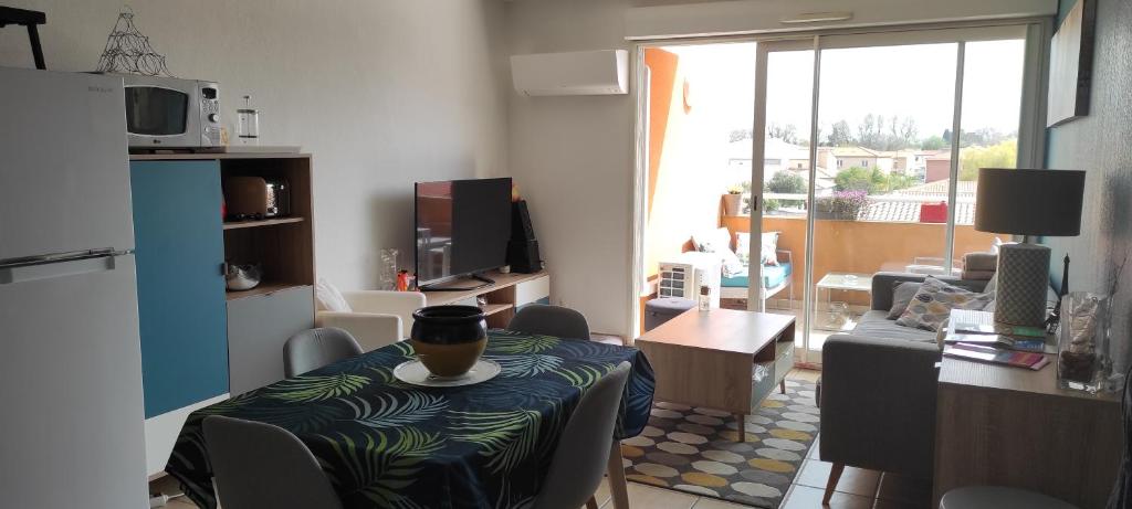 salon ze stołem i kubkiem w obiekcie Appartement avec grande terrasse à 15 mn de la mer w mieście Saint-Estève