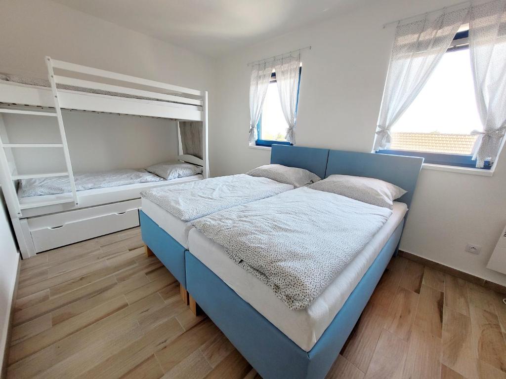 a bedroom with a blue bed and a bunk bed at Modrý sklep 77 in Velké Pavlovice