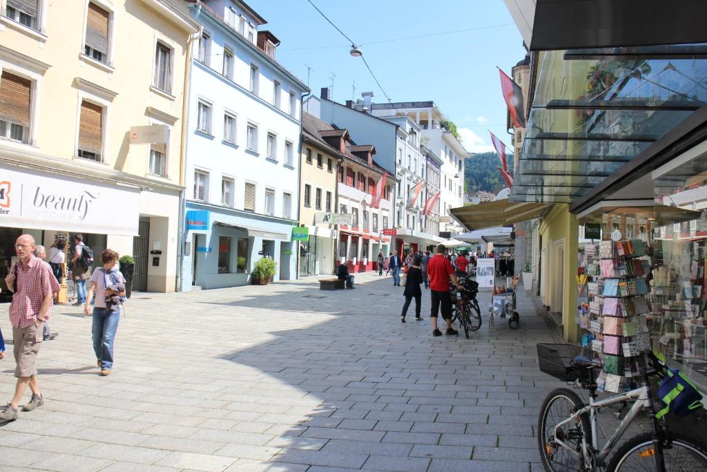 un grupo de personas caminando por una calle con edificios en Bed & Breakfast Sonne en Bregenz