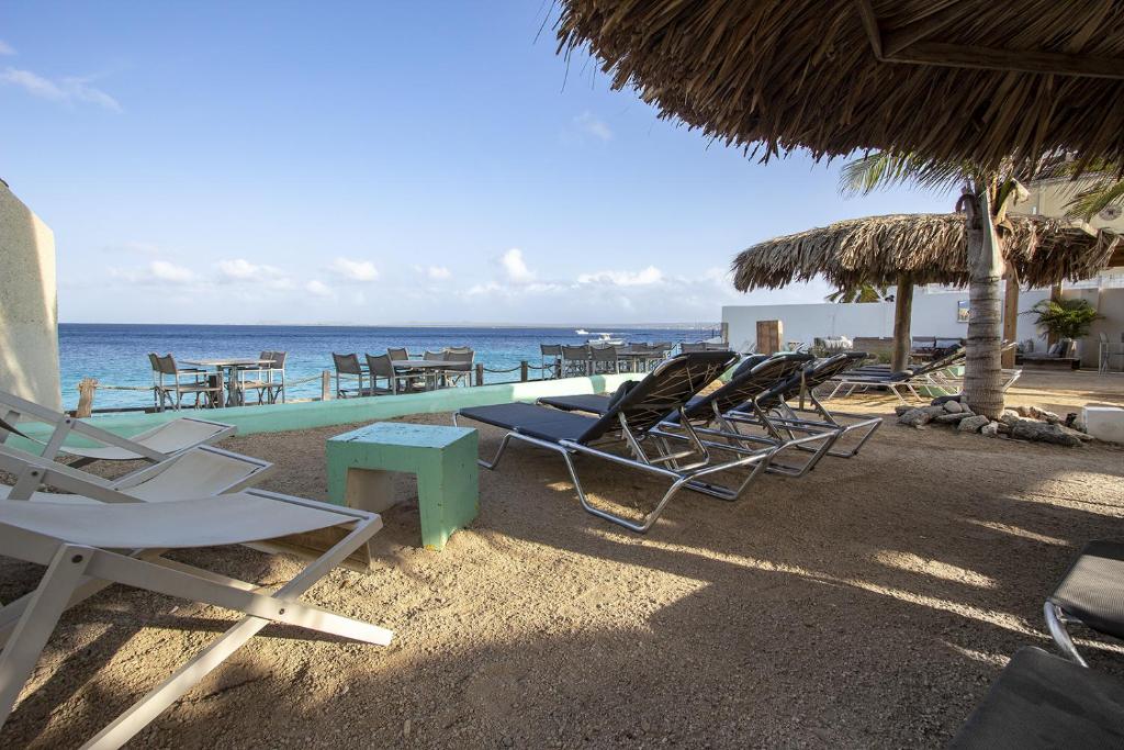 a group of chairs and tables on a beach at Windsock Apartment Caribbean Dream in Kralendijk