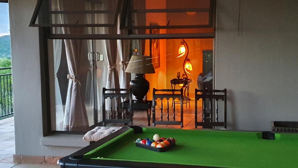 a living room with a pool table and a room with at 113 Zwartkloof Private Game Reserve Bela-Bela in Bela-Bela