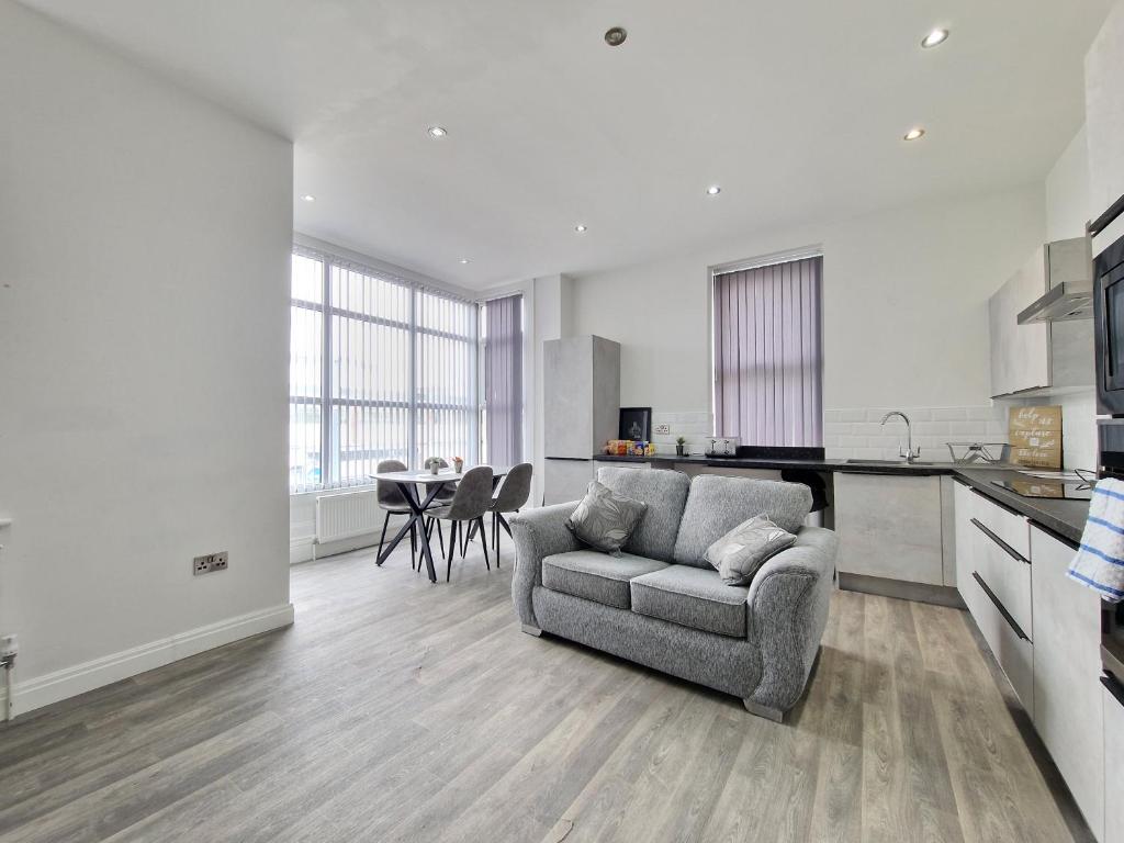 a living room with a couch and a kitchen at DYSA Waterloo Apartments in Blackpool