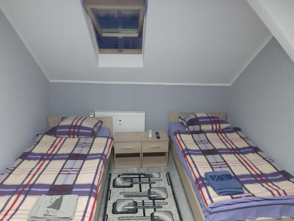 two twin beds in a small room with a window at 1 Zimmer Wohnung für 1-2 Gäste in Gößnitz