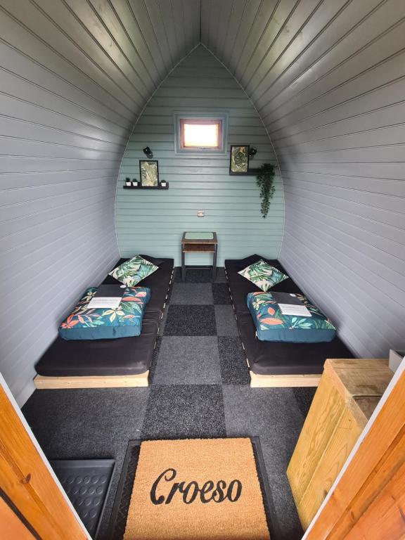 a room with two beds in a small room at Delightful Camping Pod in Snowdonia, North Wales. in Derwen