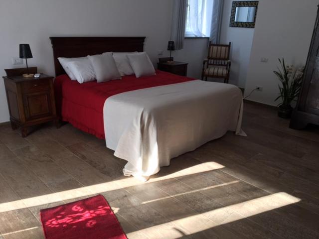 a bedroom with a large bed with a red blanket at Il Giardino dei Desideri in Viterbo