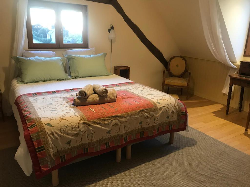 um quarto com uma cama com um urso de peluche em Le cottage du séquoia em Chamberet