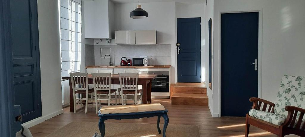 a kitchen with a table and chairs in a room at Les lunettes d'Oyo 2 in Oyonnax