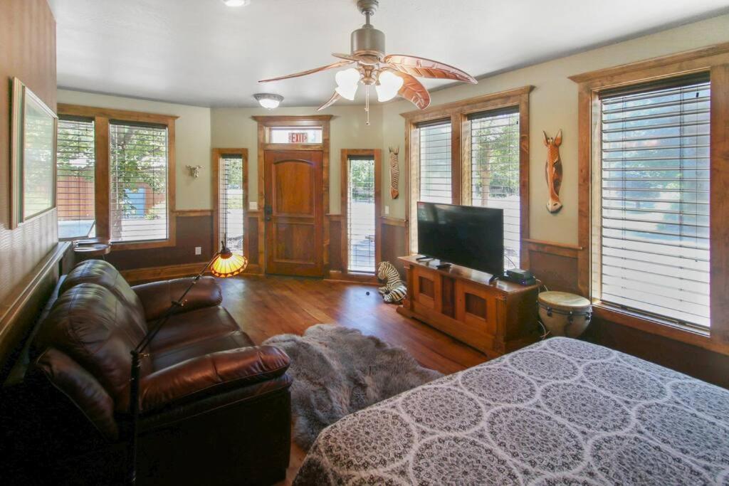 sala de estar con sofá y TV de pantalla plana en Safari Cottage, en Jacksonville