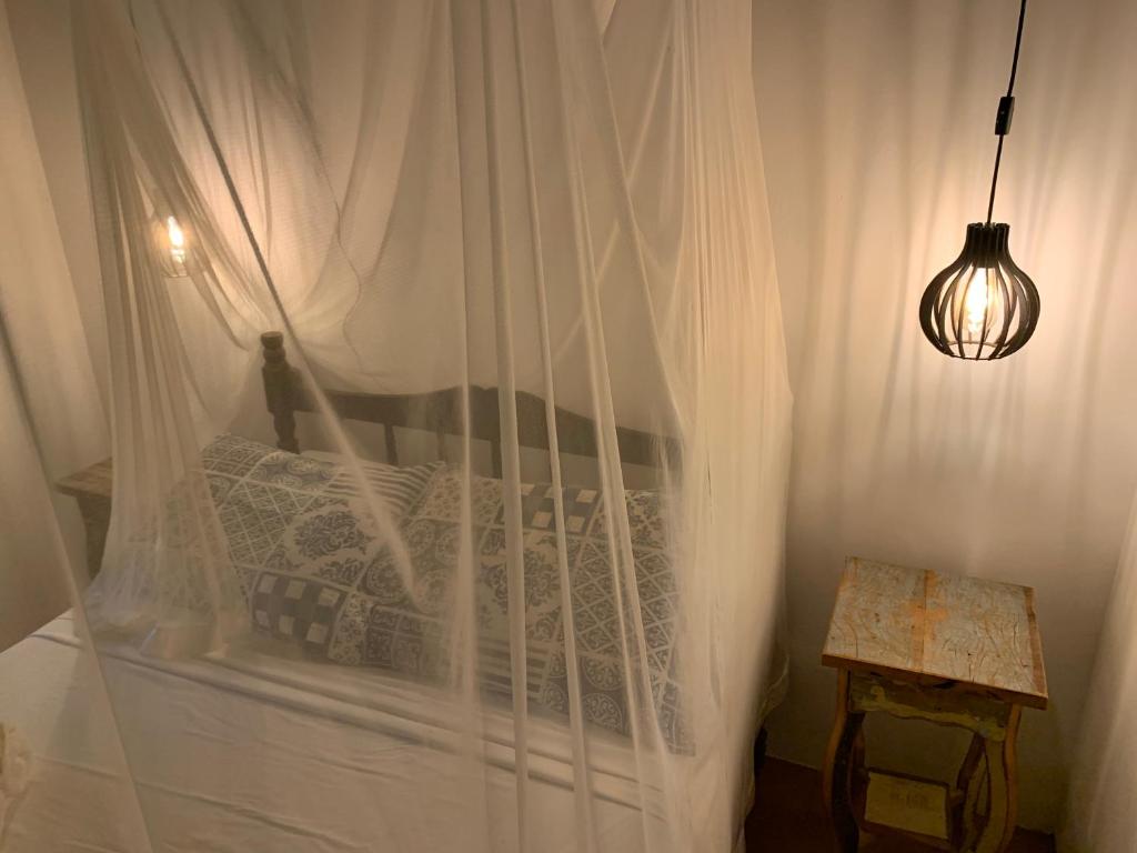 een slaapkamer met een bed met witte gordijnen bij Casa no coração da vila de Caraiva in Caraíva