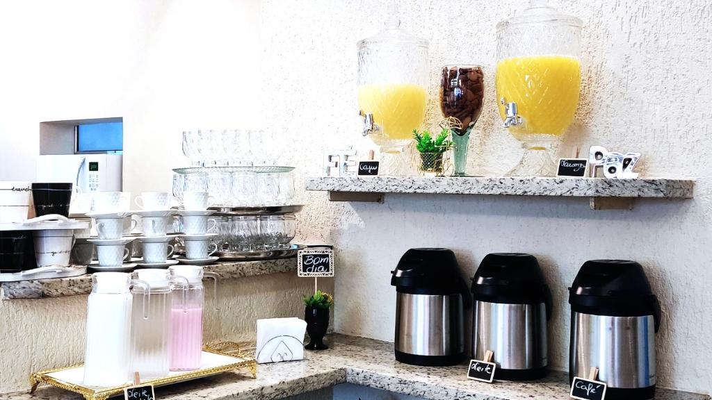 a kitchen with a counter with two shelves with orange juice at HOTEL ROCHA - Olímpia in Olímpia