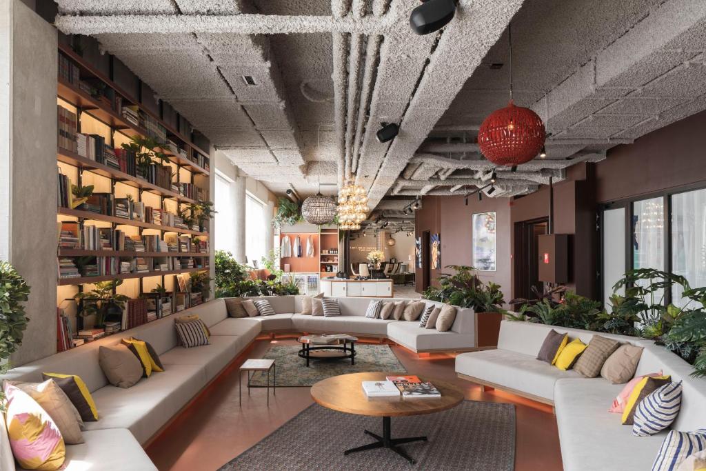 a living room with couches and tables and plants at YUST Liege in Liège