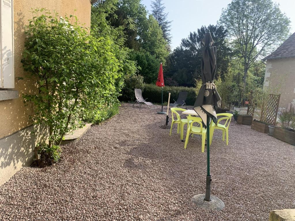 a patio with chairs and an umbrella on a pole at Appartement La Roche-Posay, 2 pièces, 5 personnes - FR-1-541-40 in La Roche-Posay